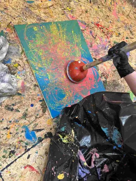 Actionpainting mit Pümpel-Technik auf türkiser Leinwand