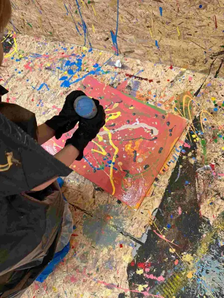Farbe wird auf rote Leinwand geschleudert